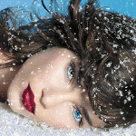 Close-up portrait of a woman’s face with blue eyes and red lips, snowflakes resting on her hair and skin, used as a forum avatar/profile photo.
