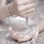 Close-up forum avatar of a beautiful woman: soft-focus hands with glitter cascading between cupped palms.