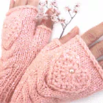 Close-up of a woman's hand wearing a beautiful pink knitted glove with a textured heart design and delicate beads, styled as a forum avatar/profile photo.