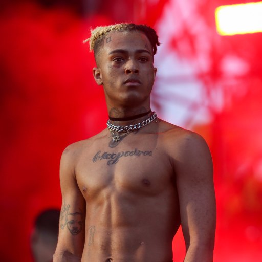 Shirtless young male performer with braided hair and chokers under red stage lights, used as a forum avatar/profile picture — tags: XXXTentacion, music.