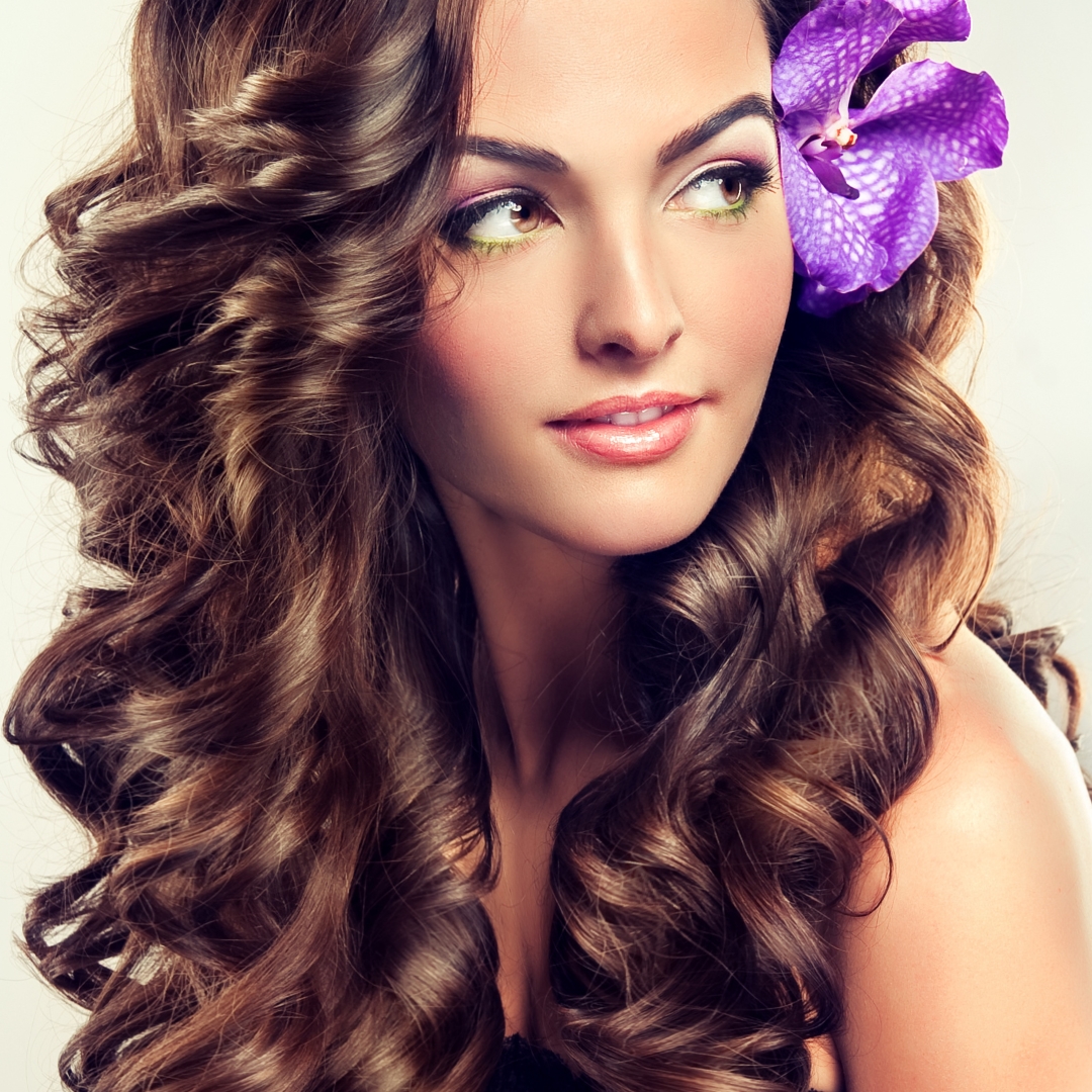 Beautiful girl with long curly brown hair , flower in hair by Sonya Zhuravetc