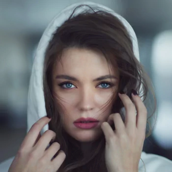Forum avatar: close-up of a brunette woman model with blue eyes and lipstick, a hood framing her face.