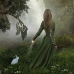 Fantasy-themed forum avatar of a woman in a flowing green dress standing in a misty forest, reaching out toward a glowing, mystical light near the ground.