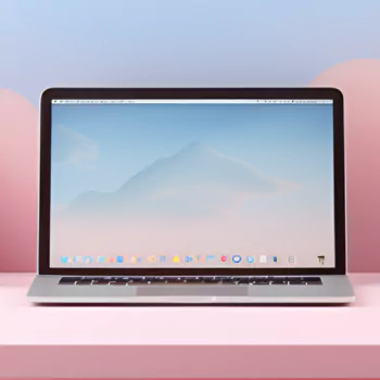 A sleek laptop sits on a pink surface, displaying a soft, gradient background. This artistic design makes for a distinctive forum avatar or profile photo.