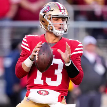 Avatar of a quarterback in a red NFL jersey marked with the number 13, poised to make a pass during a football game, embodying the energy of the Super Bowl sports event.