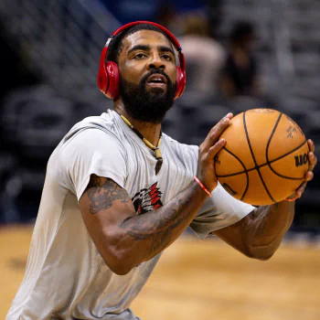 Avatar photo of athlete Kyrie Irving on a basketball court, wearing a white shirt and red headphones, holding a basketball in shooting position.