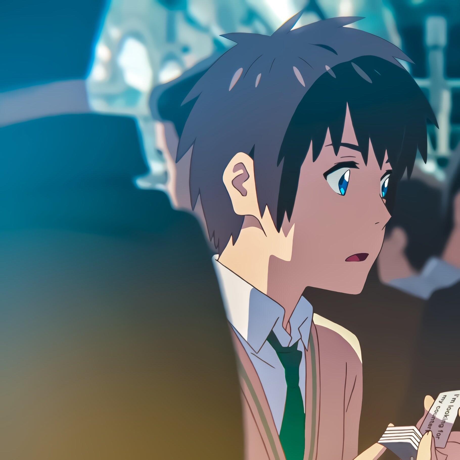 An avatar featuring Taki Tachibana from the anime Your Name. He has short dark hair and is depicted looking contemplatively while holding a piece of paper in a busy setting.