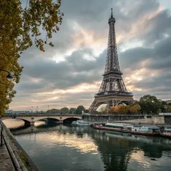 An iconic view of the Eiffel Tower in France, reflecting in the Seine River under a dramatic sky, ideal for a forum avatar or profile photo.