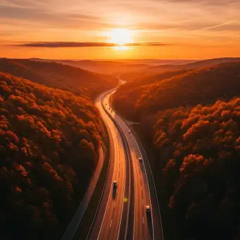A winding highway stretching through autumn-colored hills at sunset, used as a forum avatar/profile photo.