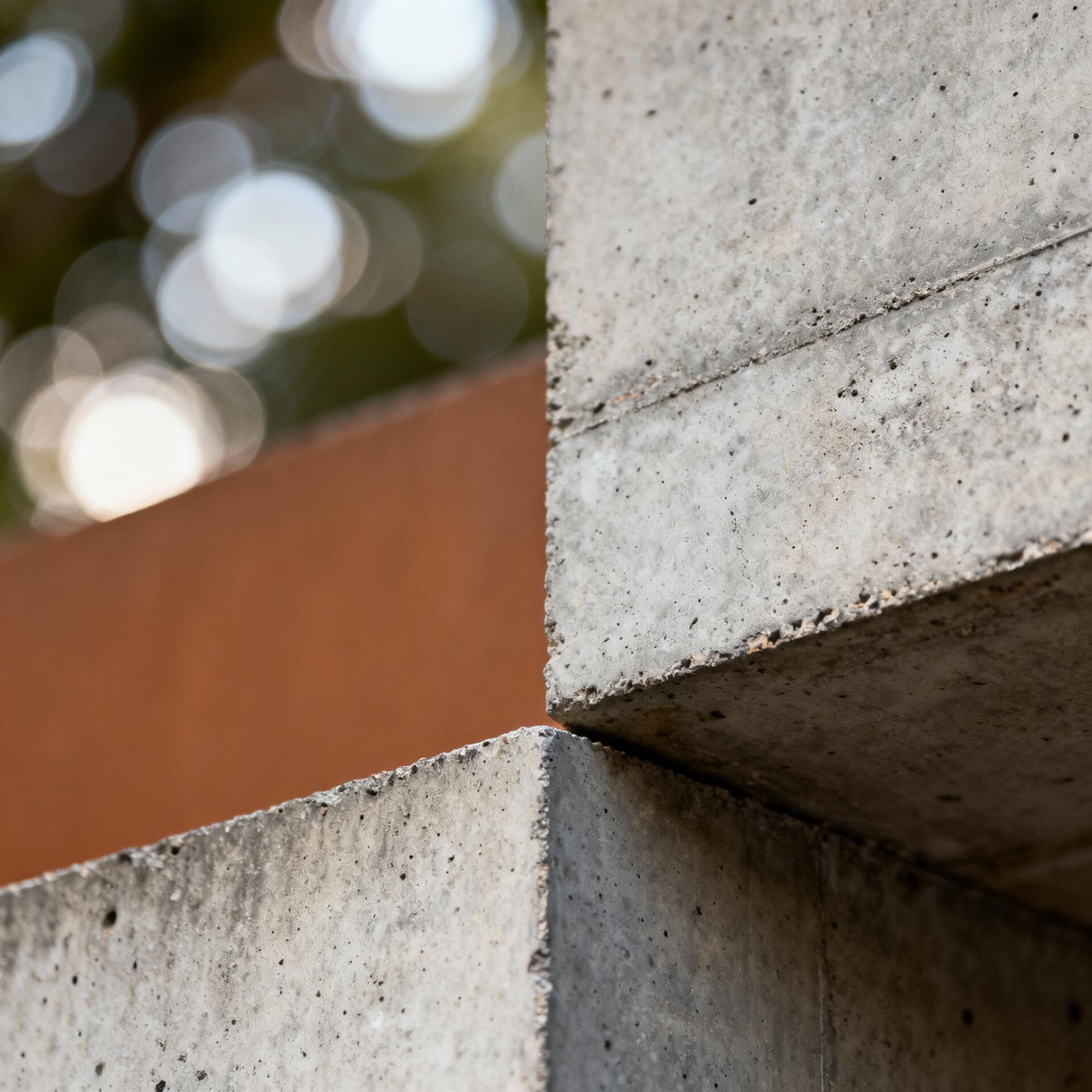 Forum avatar/pfp: minimalist close-up of stacked concrete ledges with warm, circular bokeh lights softly blurred in the background.