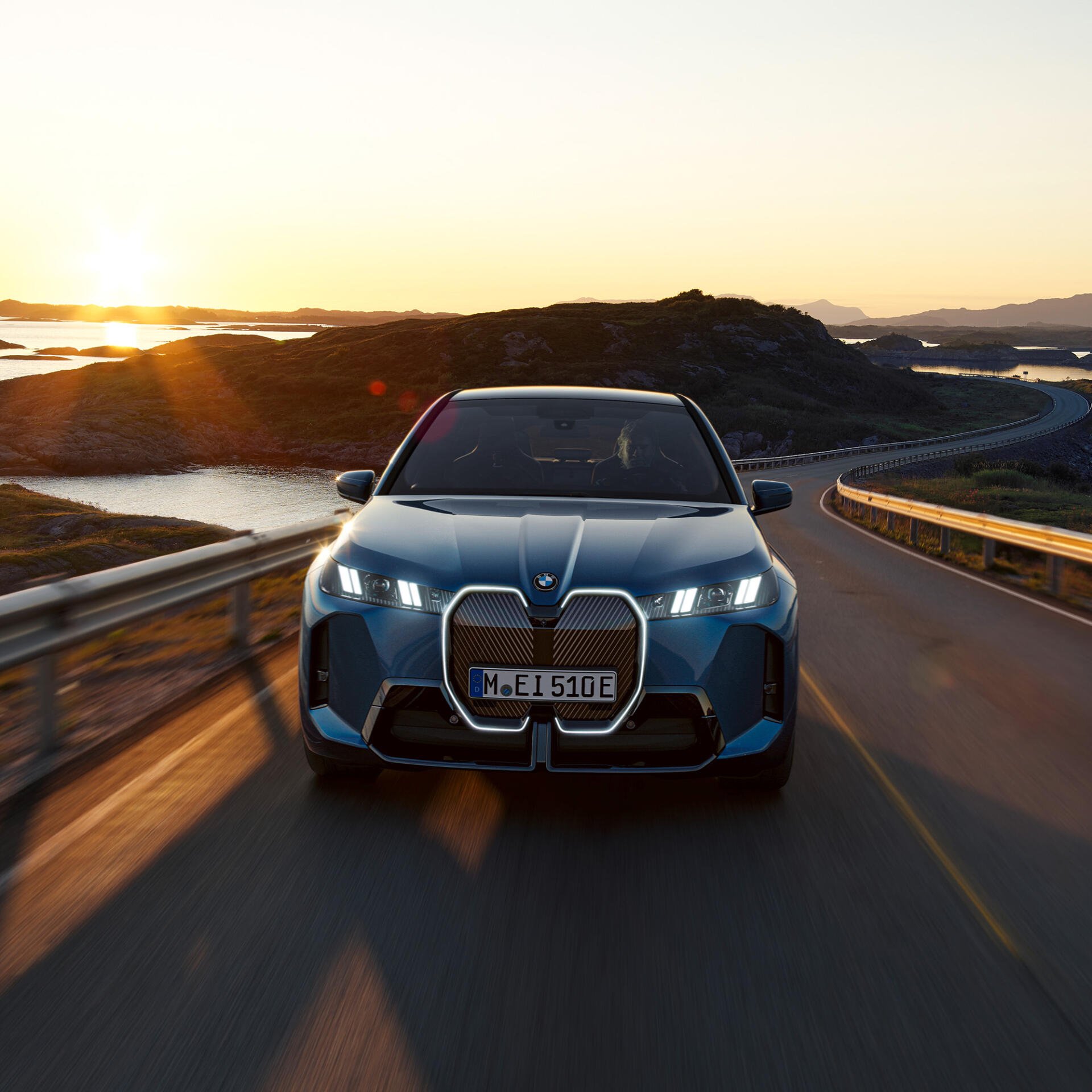 Profile avatar showing a blue BMW iX electric SUV driving toward the camera on a coastal road at sunset.