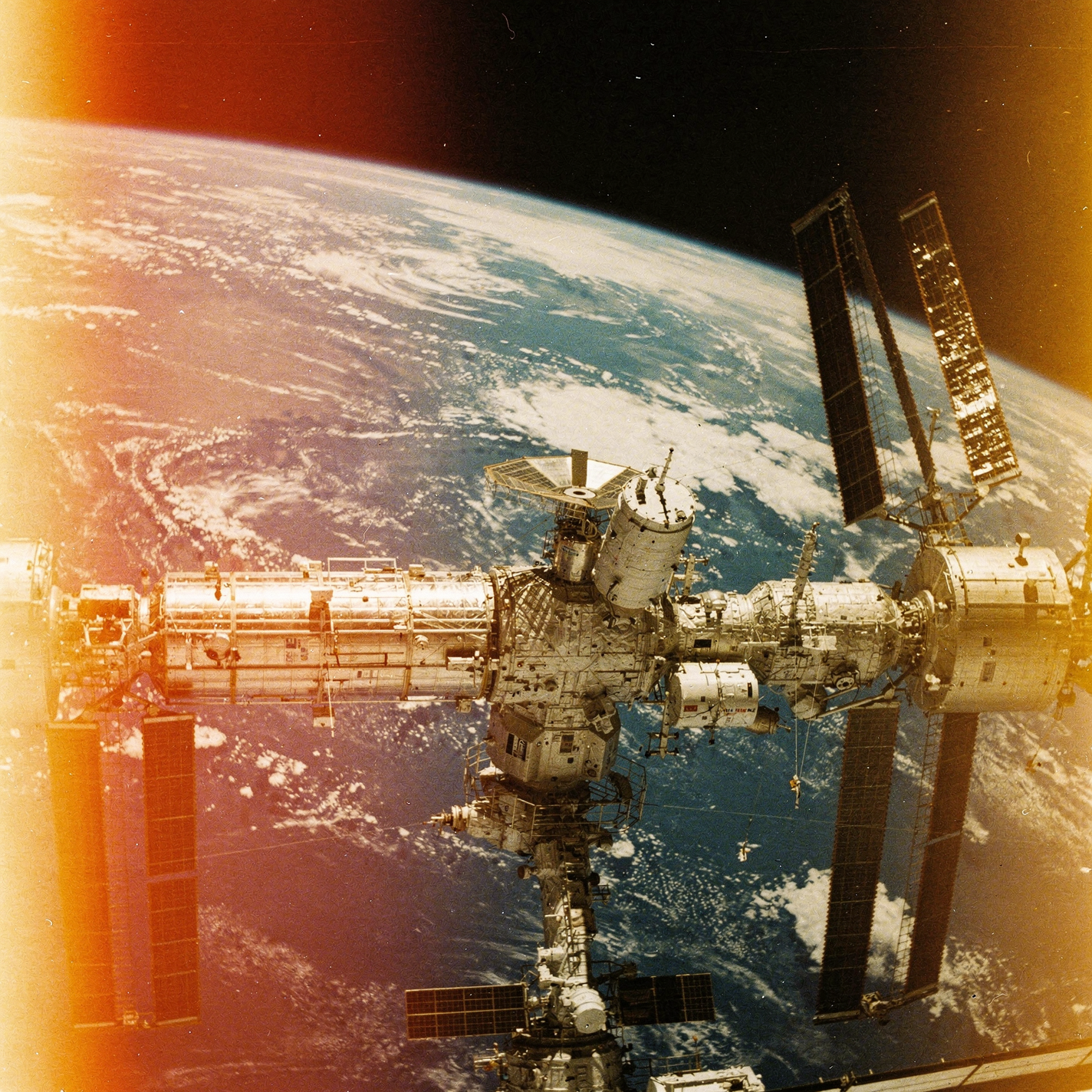 Forum avatar of the International Space Station orbiting Earth, sunlit solar panels and warm lens flare.