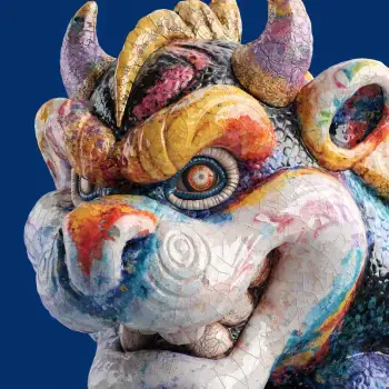 Close-up of a colorful Bowser-inspired monster mask sculpture used as a forum avatar, showing textured paint, curled horns and spiral-patterned eyes on a blue background.