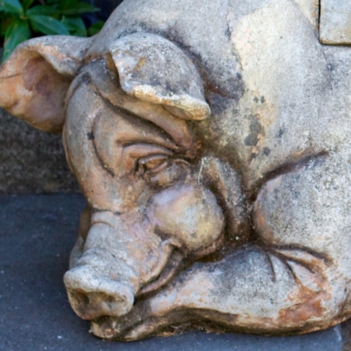 Stone pig sculpture on a bench used as an avatar or profile picture.