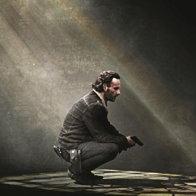 Forum avatar inspired by The Walking Dead: a rugged man crouched with a handgun in a shaft of light, pensive and watchful in profile.