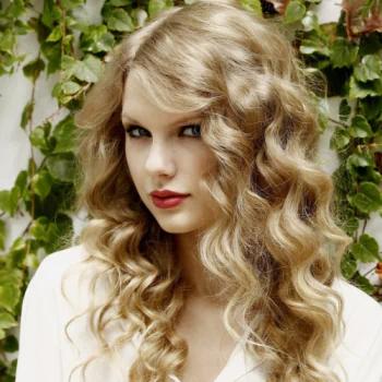 Forum avatar: close-up portrait of a blonde woman with long glossy curls and red lips, evoking a pop singer's style and musical fandom.