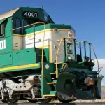 Profile picture of a green and yellow train engine number 4001 against a clear blue sky.