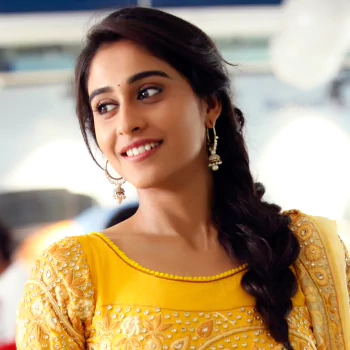 Profile photo of celebrity Regina Cassandra smiling, wearing a yellow traditional outfit with intricate embroidery and long braided hair adorned with earrings.
